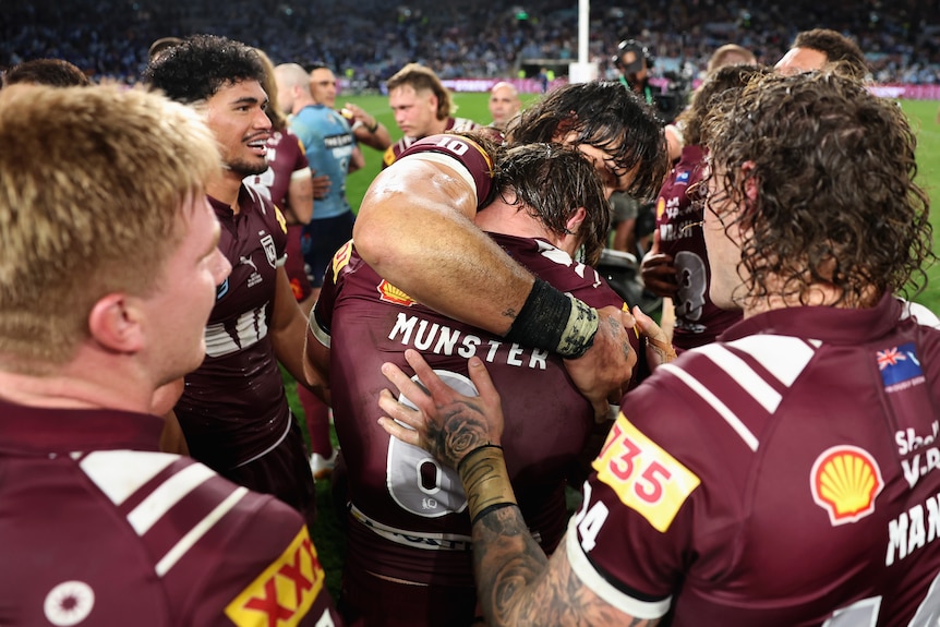 Cameron Munster is embraced by his teammates after State of Origin.