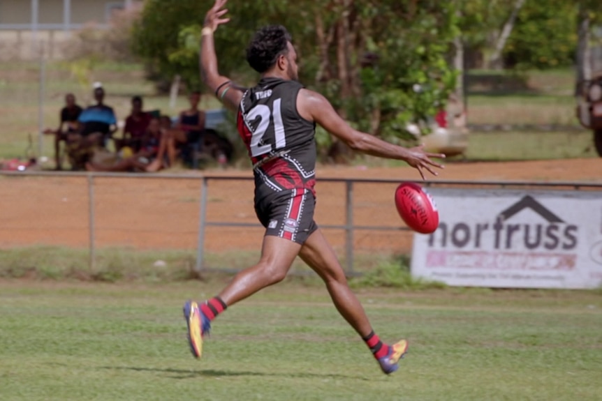 Football player Willie Rioli prepares for a kick.