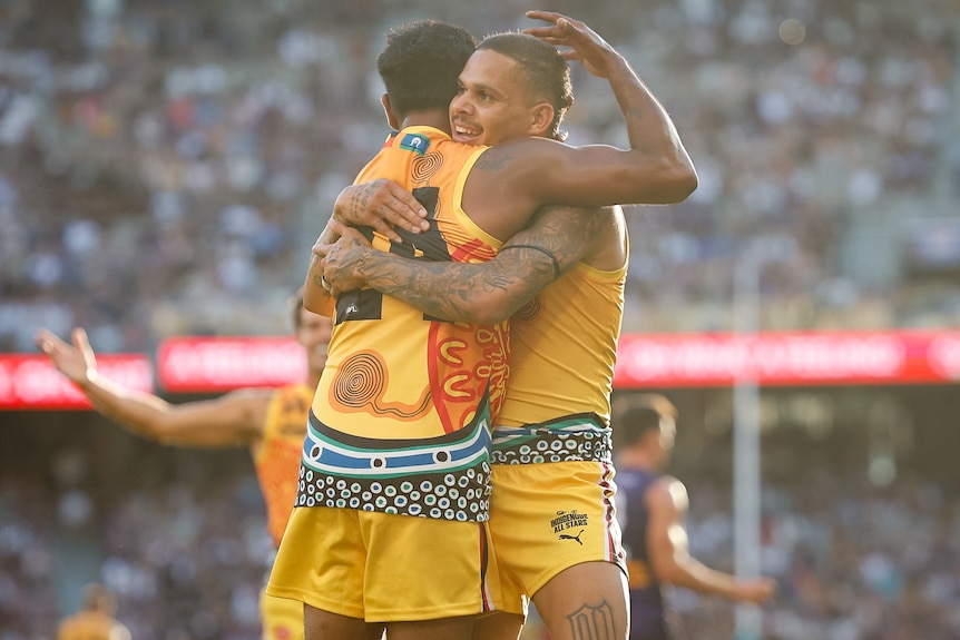 Willie Rioli Jr and Bobby Hill share an embrace.