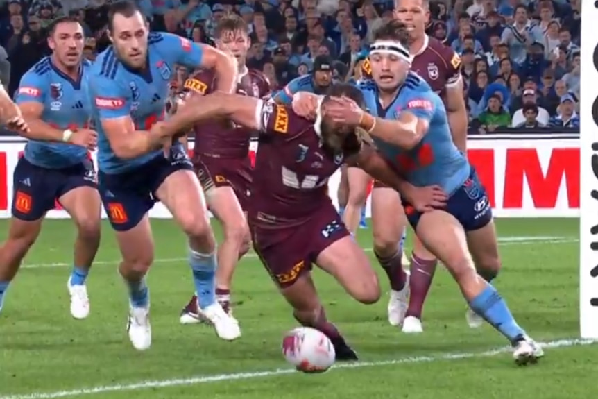 A screenshot of Cameron Murray holding back Kurt Capewell during State of Origin I.