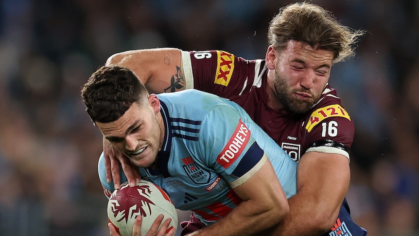 Nathan Cleary of the Blues is tackled by Patrick Carrigan of the Maroons