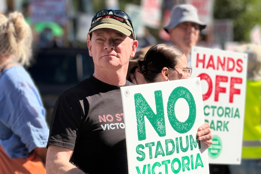 Campbell Newman holds a sign that says: "No stadium".