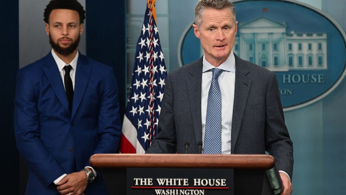 Stephen Curry looking on as Steve Kerr speaks in the White House briefing room
